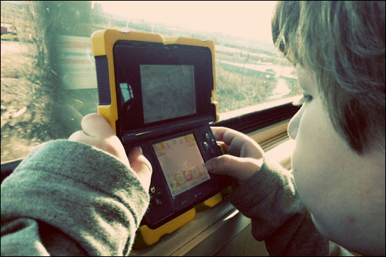 Child playing video games on train